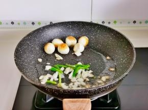 再加入葱段，蒜末炒出香味儿。