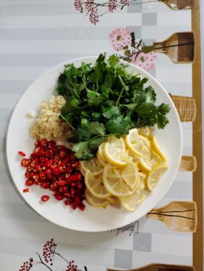 蒸鸡腿的时候，我们来准备料汁儿：
小柠檬洗净切成片，把柠檬的籽去掉！小米辣切成圈，蒜瓣切成蒜末，香菜洗净切成段备用！
