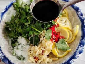 碗中放入切好的柠檬片，小米辣，蒜末，香菜，白糖，太太乐鲜贝露调味汁！