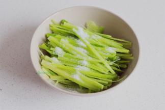 青萝卜去皮，先切薄片，再切丝，然后放盐，拌一拌，搓一搓，把萝卜水倒掉。萝卜皮其实也可以吃，特别脆甜，喜欢吃萝卜皮可以不去皮哦。