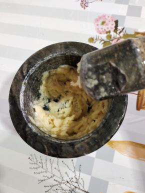 蒸槐花的时候，我们来调料汁儿！先把蒜瓣放在兑窝里，加一勺盐，捣成蒜泥！