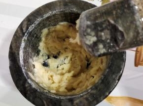 蒸槐花的时候，我们来调料汁儿！先把蒜瓣放在兑窝里，加一勺盐，捣成蒜泥！