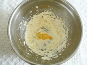 电动打蛋器，中速打发至黄油颜色变浅发白，体积明显蓬松。分3次加入常温全蛋液，每次搅打完全混合再加，直到蛋液全部加完！注意：蛋液必须常温，温差过大黄油糊会油水分离。