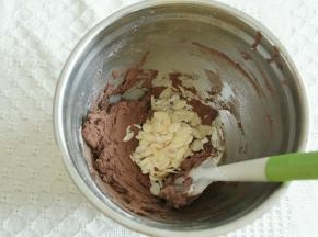 用切拌、往盆边按压的方法拌匀至没有干粉颗粒。倒入杏仁脆片拌匀。