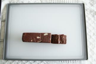 预热烤箱上下160度。取出定型好的饼干胚，切成0.6毫米的均匀薄片。