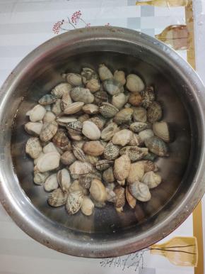 花甲买回来，放入盆中，加入适量的盐，浸泡半个小时，让它把里面的泥沙吐出来！！再清洗干净备用！