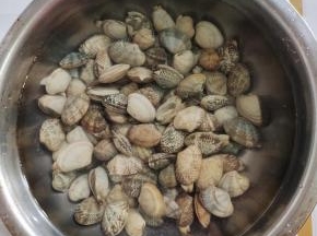 花甲买回来，放入盆中，加入适量的盐，浸泡半个小时，让它把里面的泥沙吐出来！！再清洗干净备用！