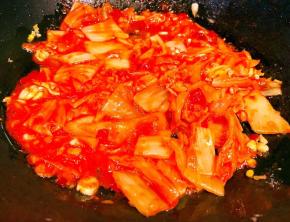 锅中倒入底油加热放入蒜粒爆香再放入辣白菜炒匀