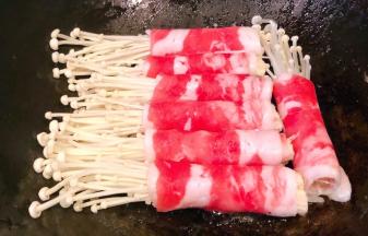 锅中倒入少许底油加热放入肥牛金针菇卷中火煎起来