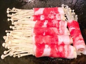 锅中倒入少许底油加热放入肥牛金针菇卷中火煎起来