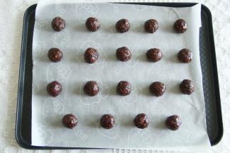 预热烤箱，上下180度。带上PVC手套，分成15克一个，搓成球，排入垫了油纸的烤盘上。