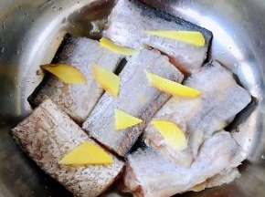 姜片依次摆在带鱼上煨制十分钟左右