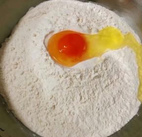 取适量面粉放入容器中打入一个鸡蛋这样制作出来的饺子皮特别劲道