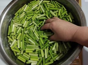 切好的蒜苔放入盆中，向里面加入没过蒜苔的清水。再加入两勺盐，抓一抓使盐化开！（这样可以去除蒜苔的辛辣味，吃的时候不烧心！）