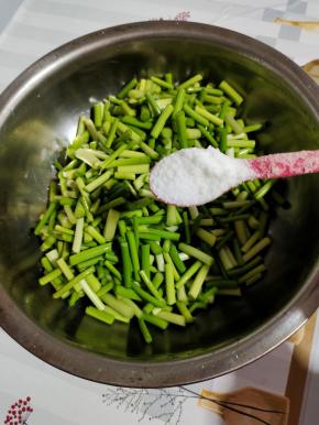浸泡好的蒜苔，捞出沥干水分，放入盆中，加入两勺盐翻拌均匀！
