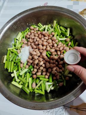 花生放凉后，倒入蒜苔里，加入一勺白糖（如果不喜欢放糖的也可以不加！），最后再加入一瓶盖高度白酒！