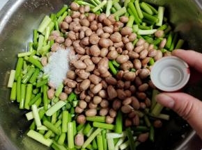 花生放凉后，倒入蒜苔里，加入一勺白糖（如果不喜欢放糖的也可以不加！），最后再加入一瓶盖高度白酒！