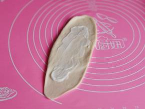 取一个面团擀长舌状，涂上沙拉酱。