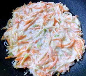 锅中倒入底油加热后淋入土豆胡萝卜糊切记不宜太厚中火煎起来