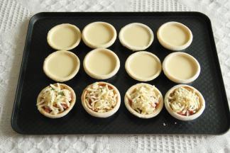 步骤9、把冷冻中的其余6只挞皮取出，8只倒入挞液。其余4只，刷上一层黑椒酱，放上培根、甜玉米、豌豆，撒上芝士碎。