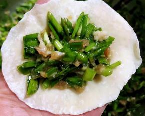 取适量馅料放在饺子皮中间饺子皮对折捏紧两端空着不要捏住