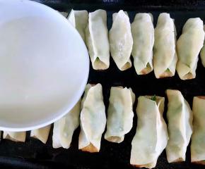 锅贴煎至七成熟倒入淀粉水再盖上锅盖中小火煎