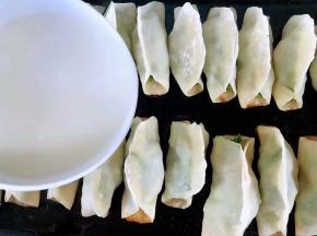 锅贴煎至七成熟倒入淀粉水再盖上锅盖中小火煎