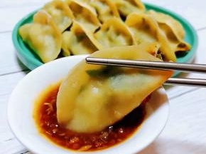 锅贴入口香浓四溢蘸着料汁吃起来别有一番滋味