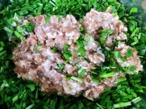 韭菜摘好洗净沥干水份切成小段放入容器中再放入入味的肉馅