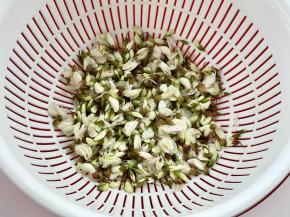 把槐花挑出绿叶，洗净沥干水。