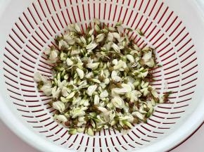把槐花挑出绿叶，洗净沥干水。