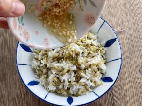 把煮好的槐花饭盛入碗中，浇上调好的调味汁。拌匀后就可以吃啦！