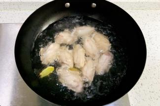 锅中倒入适量的清水，鸡翅冷水下锅，加料酒和姜片煮开，焯水捞出。