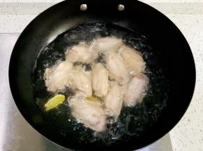 锅中倒入适量的清水，鸡翅冷水下锅，加料酒和姜片煮开，焯水捞出。