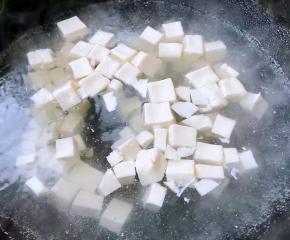 豆腐切成大小均匀的小块状放入开水中烫一下