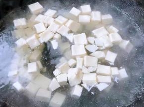 豆腐切成大小均匀的小块状放入开水中烫一下