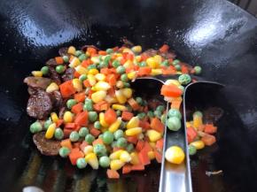 加入胡萝卜、豌豆米和玉米粒翻炒均匀