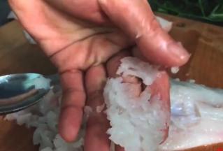 用不锈钢勺子把鱼肉刮下来