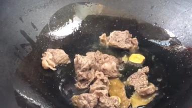 放入牛腩肉炒干水分，再加料酒炒香
