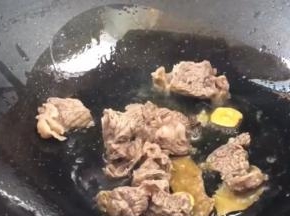 放入牛腩肉炒干水分，再加料酒炒香