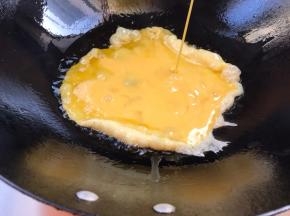 起锅热油，油温6成热时倒入蛋液