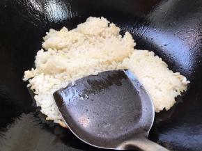 用锅铲把热饭按压炒散