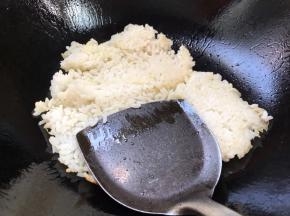 用锅铲把热饭按压炒散