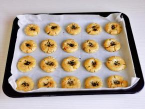 团成等份的小面团，按扁摆在垫好油纸的烤盘中，手指沾一下芝麻，再按再中间即可。