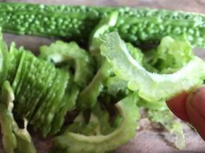 苦瓜洗净切两边，用勺子挖出里面的瓜瓤和籽，切成薄片