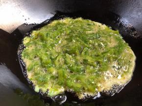 起锅放油，冷油倒入苦瓜鸡蛋，中火煎约2分钟（记得经常晃动锅子）