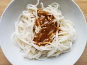 将调好的酱汁浇在面条上。 