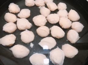 挤出的丸子用蘸水的瓷勺刮起，一个丸子就成型了，放入锅里