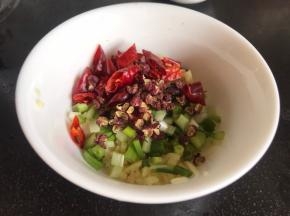 备好葱姜蒜末、花椒和干辣椒装入小碗中