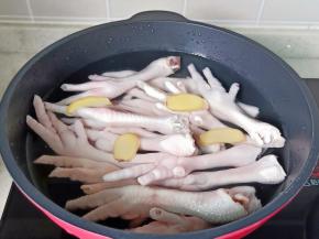 鸡爪冷水下锅，放入姜片 。